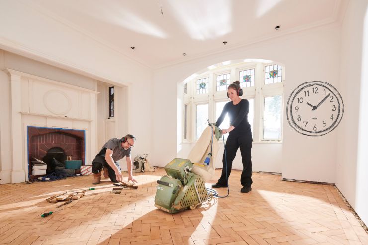 persone che stanno ristrutturando casa con accanto un orologio
