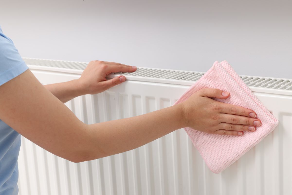 donna che pulisce i termosifoni