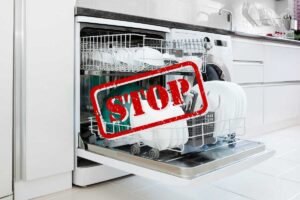 una lavastoviglie di una cucina con davanti il segnale di STOP