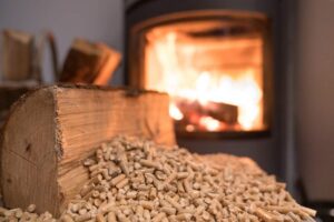 Una stufa a pellet sullo sfondo con in primo piano il pellet