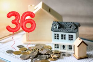 casa in miniatura, monete e palloncini col 36
