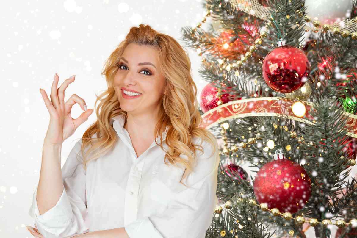 donna che fa segno ok e albero di natale