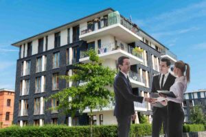 Un condominio e tre persone che parlano davanti