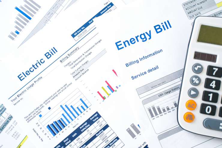 delle bollette dei consumi dell'energia elettrica e una calcolatrice sopra