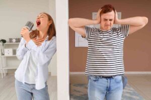 Donna canta e uomo tappa le orecchie