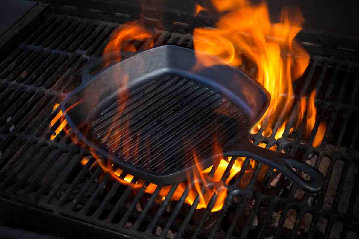 una bistecchiera in ghisa sopra alla griglia del barbecue