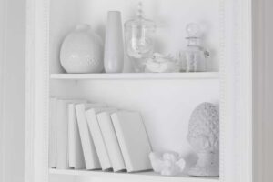 Mensola shabby chic Romantique Maisons du Monde con sopra libri e vasi di vetro