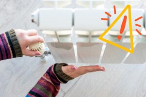 Una persona che regola la manopola di un termosifone ed un segnale in alto a sinistra di pericolo