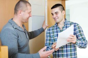 Ragazzo alla porta con foglio, proprietario di casa sull'uscio
