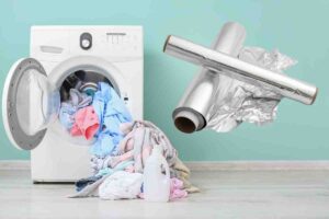 lavatrice con panni che escono da oblò e carta stagnola