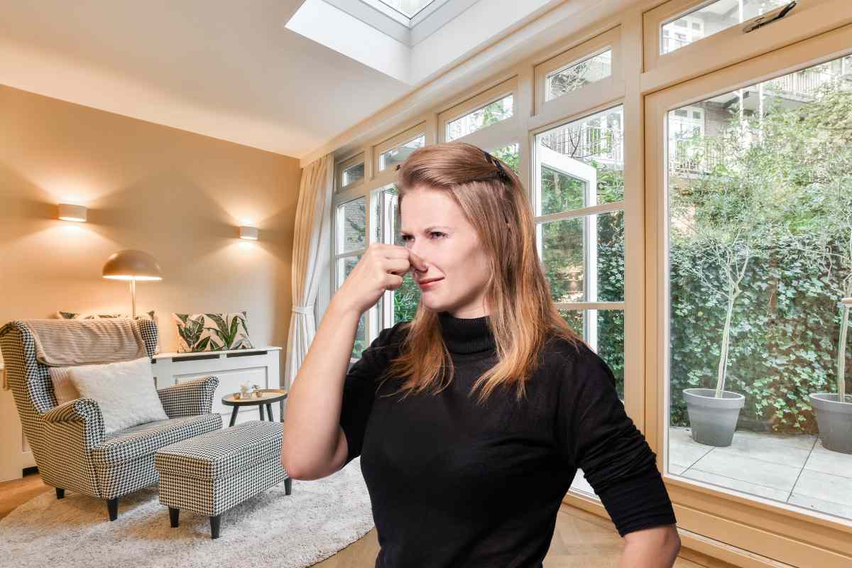 Una persona in casa che si tappa il naso perché sente cattivo odore