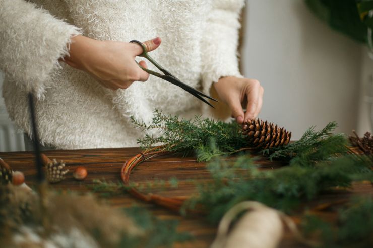 Una signora che compone una ghirlanda di natale