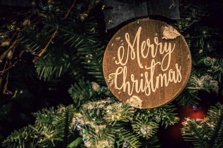 Una foto ravvicinata dell'albero di natale con un decoro scritto "Merry Christmas"