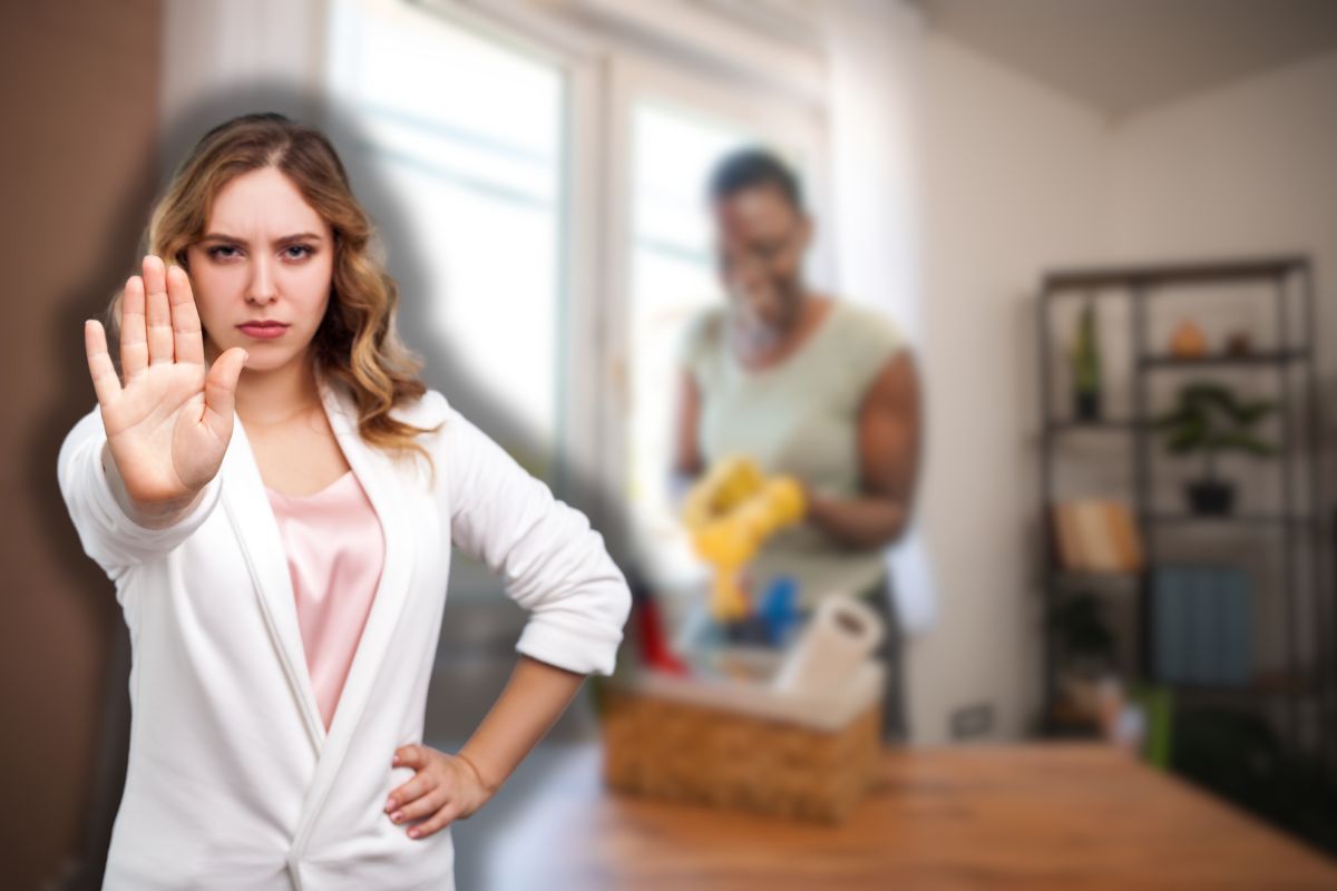 donna che fa le pulizie e un'altra che fa stop con le mani