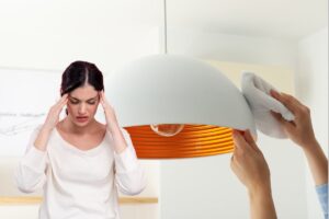 Una mano che spolvera il lampadario con una pezza ed una persona che è nervosa