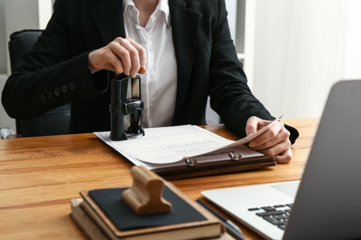 Un notaio che timbra e firma dei documenti