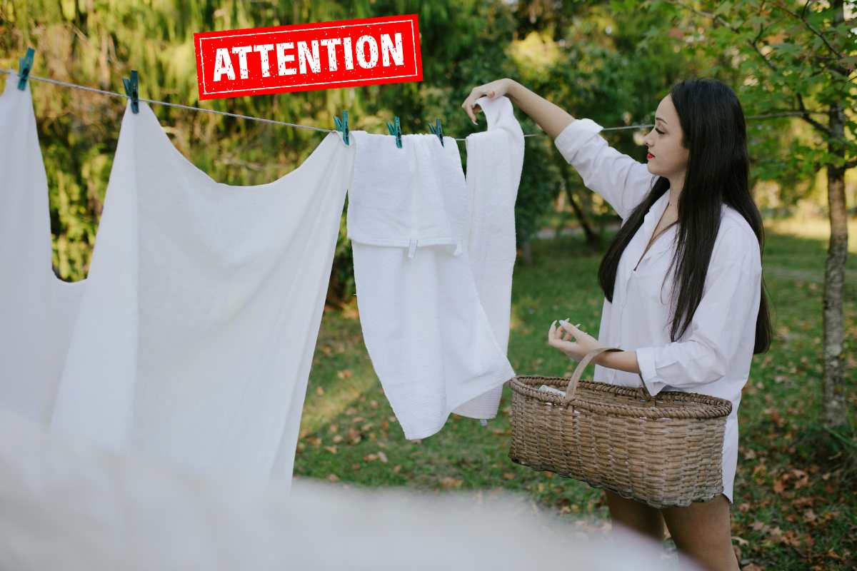 Una persona che stende all'aperto ed in alto la scritta "attention"