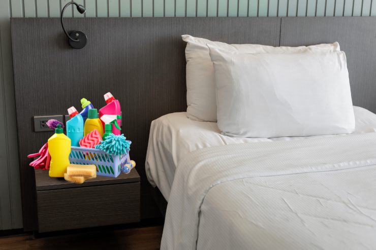 Un letto con dei prodotti di pulizia sul comodino