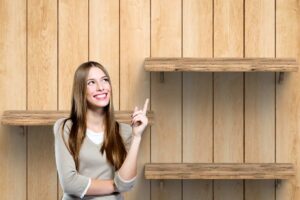 Una persona che indica felice delle mensole in legno
