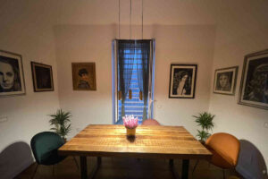 Panoramica su una sala da pranzo con tavolo in legno e sedie in velluto