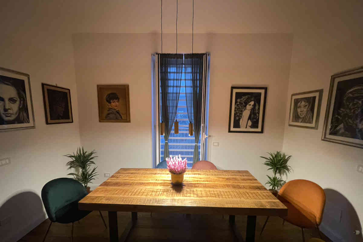 Panoramica su una sala da pranzo con tavolo in legno e sedie in velluto