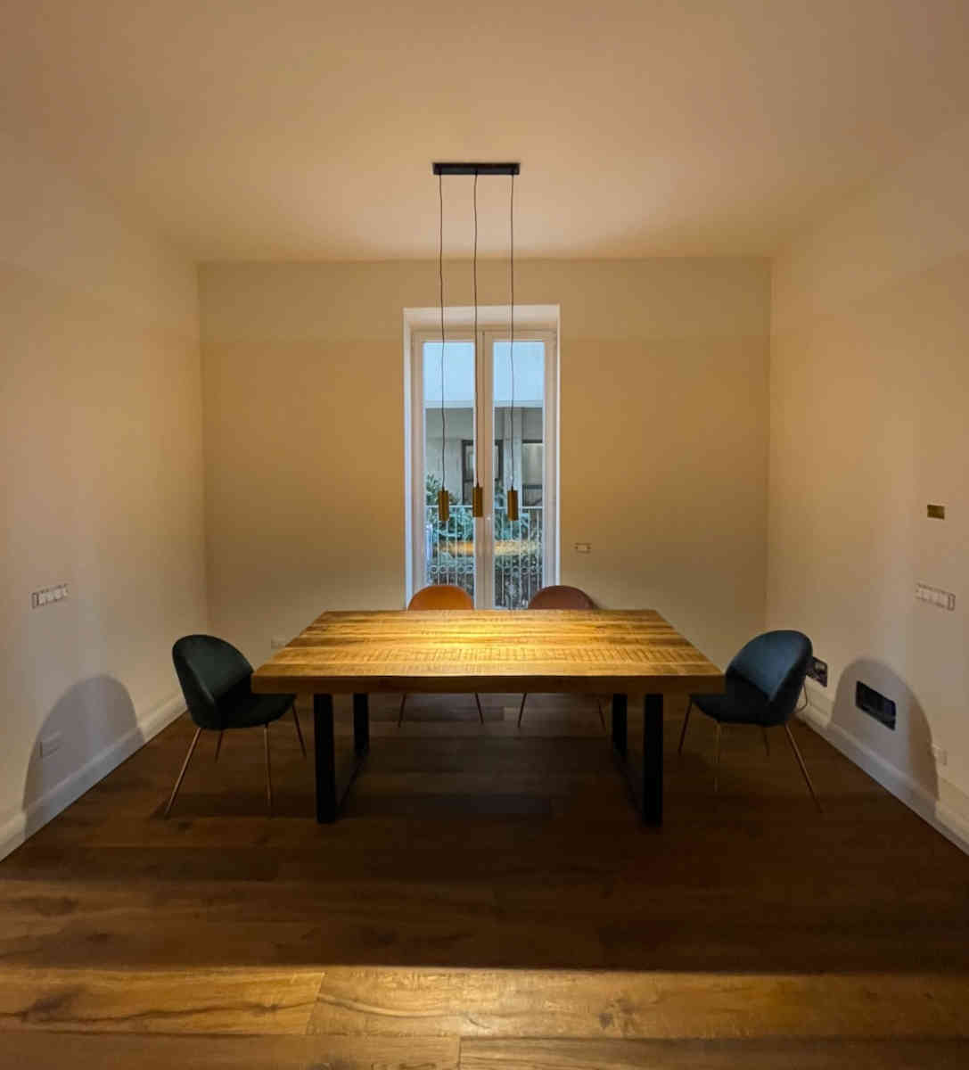 Sala da pranzo con tavolo al centro e sedie ai lati