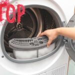 Un asciugatrice aperta ed una scritta "Stop" in alto a sinistra