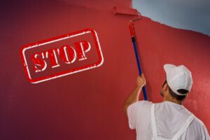 un tinteggiatore che dipinge il muro di rosso