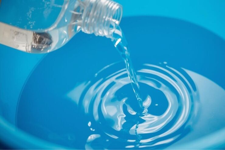 Versare aceto nel secchio dell'acqua