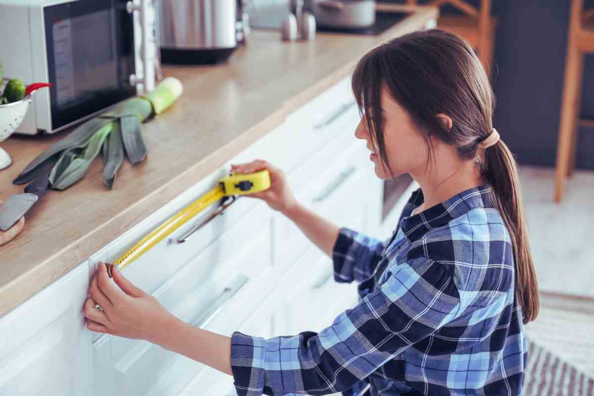ragazza che misura un mobile