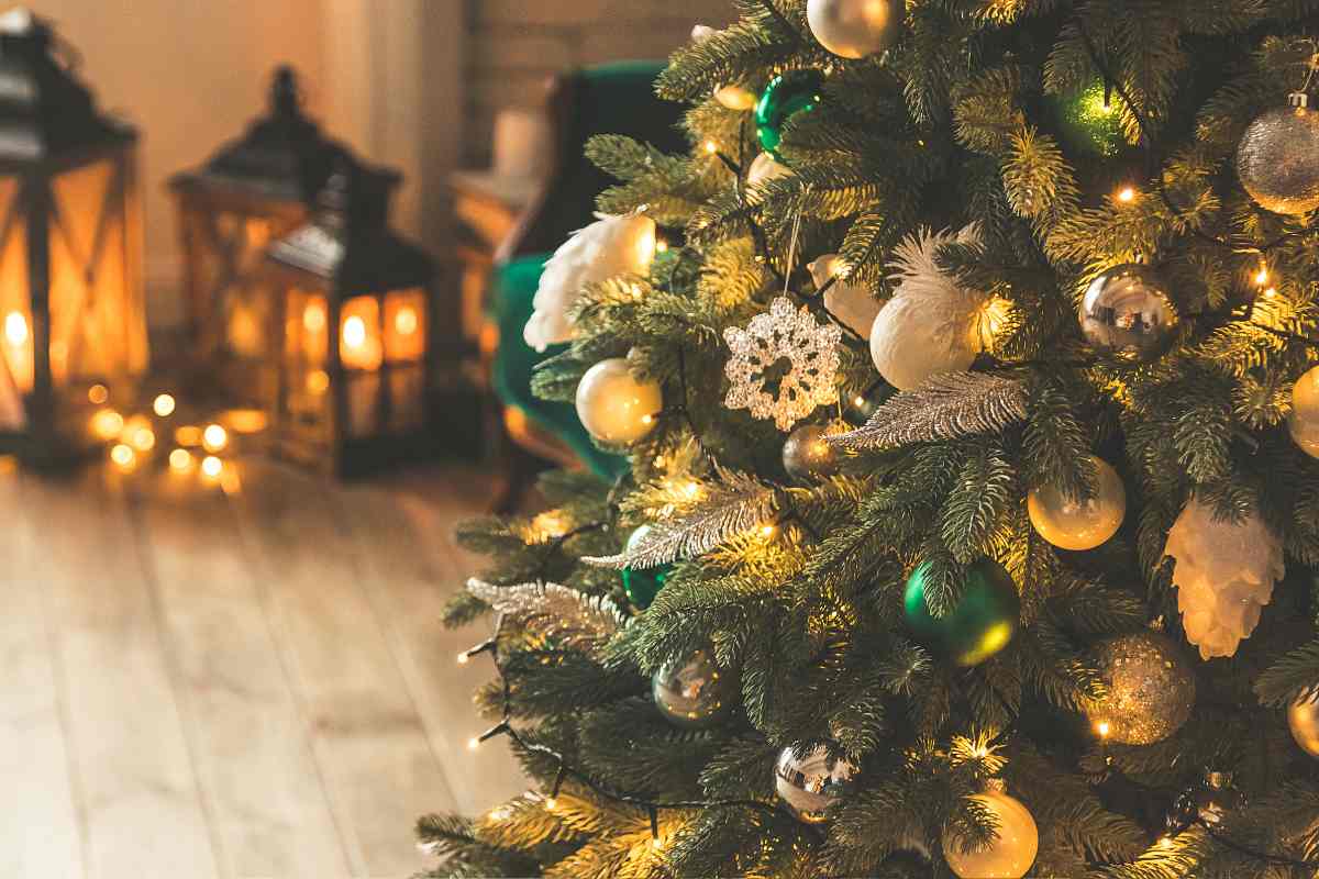 un albero di natale addobbato con sullo sfondo delle lanterne