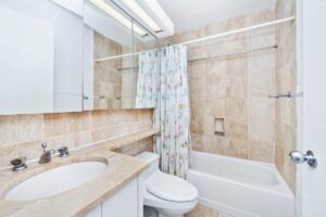 Un bagno con le piastrelle grandi che appare più spazioso