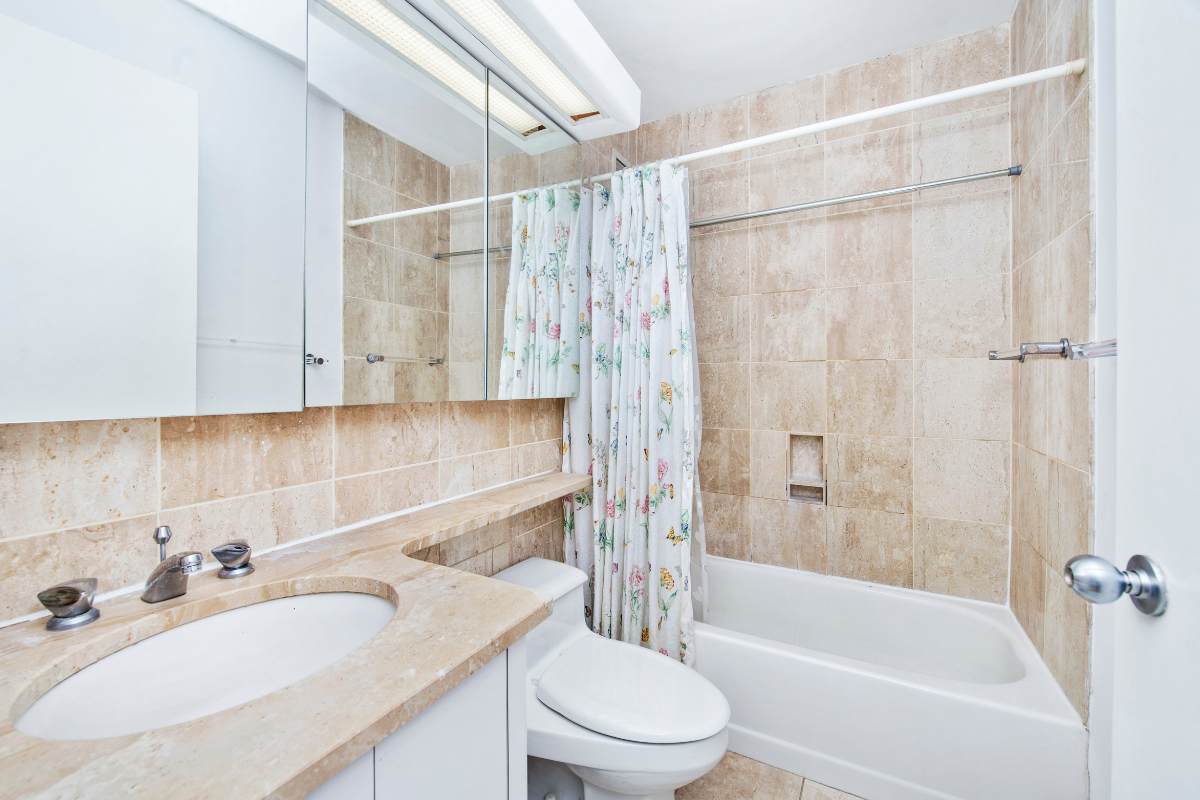 Un bagno con le piastrelle grandi che appare più spazioso