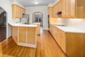 una cucina nuova in legno e piani di lavoro bianchi