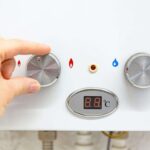 mano su caldaia che muove manopola