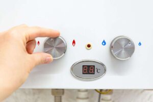 mano su caldaia che muove manopola