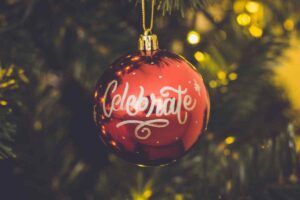 una pallina di Natale appesa con la scritta celebrate tra le decorazioni fai da te facili da fare