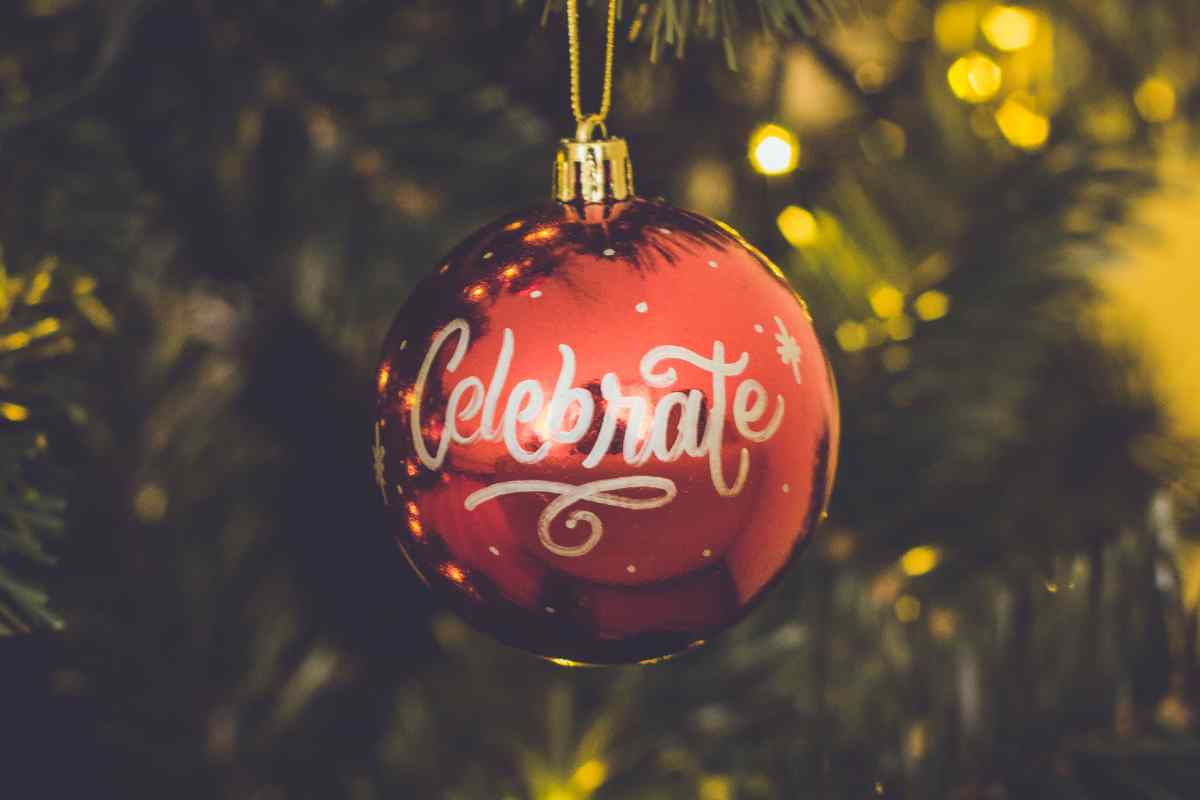 una pallina di Natale appesa con la scritta celebrate tra le decorazioni fai da te facili da fare