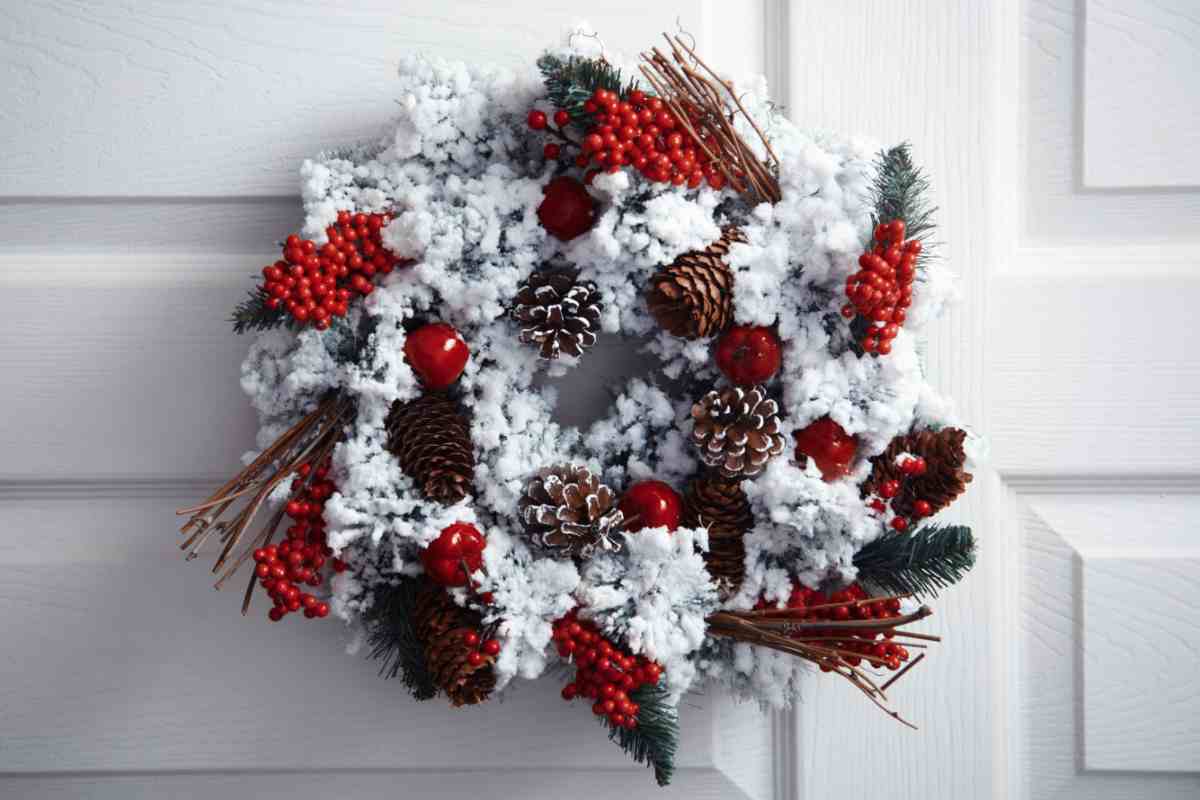 una ghirlanda natalizia fai da te effetto ghiaccio appesa sulla porta