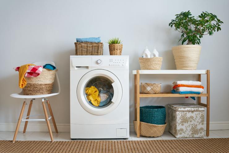 Lavatrice, un mobile e un tavolino con sopra il bucato