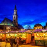 una veduta illuminata di uno dei mercatini natalizi da visitare in Italia, questo è a Bolzano
