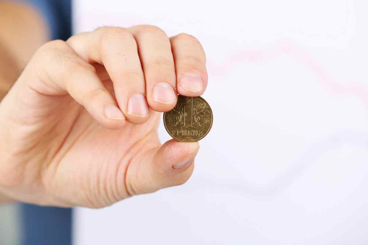 una moneta tenuta tra il pollice e l'indice mostrata frontalmente