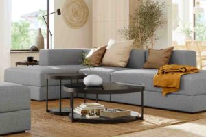 un salotto con il divano Ikea JÄTTEBO con chaise longue e un tavolino di metallo basso