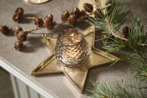 uno dei portacandele natalizi JYSK a forma di stella sul tavolo