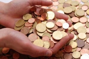 mani che raccolgono monete da un mucchio