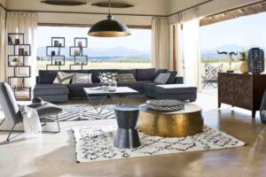 un soggiorno arredato con divano e poltrone con uno dei tavolini dorati Maisons du Monde della nostra selezione