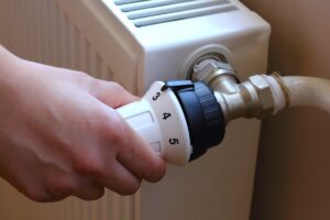 Una persona che gira la manopola per accendere i termosifoni