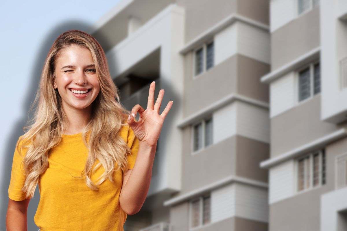 condominio e donna sorridente che fa ok con le mani