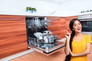 donna che indica in alto e lavatrice aperta in cucina