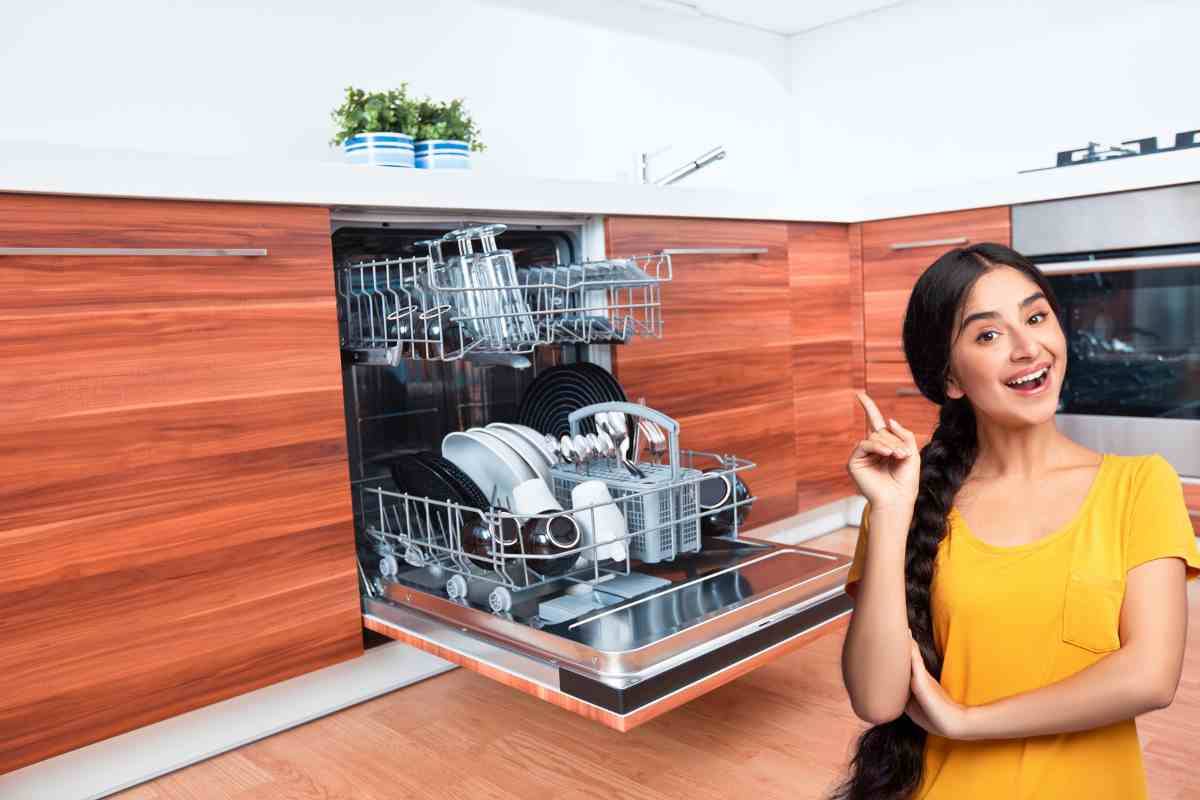 donna che indica in alto e lavatrice aperta in cucina